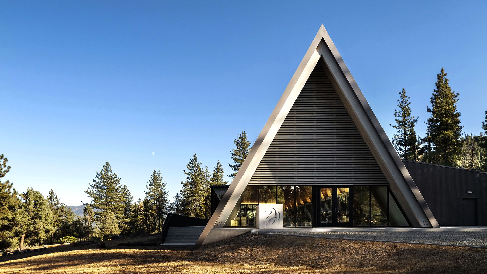 Modern A-frame residence set in a forested landscape — a CESCO site development project